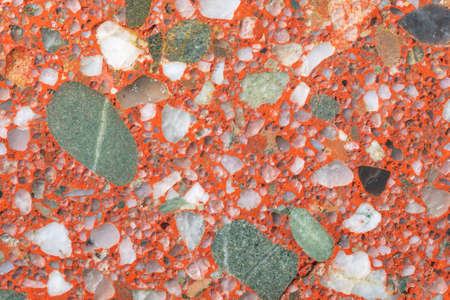 Natural stone background. A full-screen close-up texture of a red conglomerate (gravelite) with white and green grains.の写真素材
