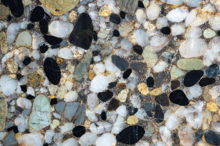 Natural stone background. The full-screen texture of conglomerate rock with white and black siliceous pebbles.の写真素材
