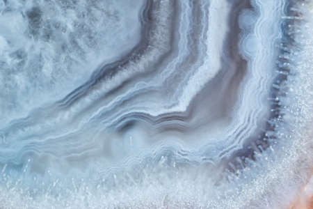 Full-screen stone texture. Close-up view of a fragment of white striped agate.の写真素材