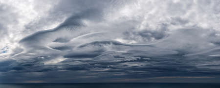 Panoramic view of dark clouds over the sea horizon.の写真素材
