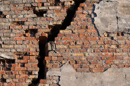 An old brick wall with a large vertical crack.の写真素材