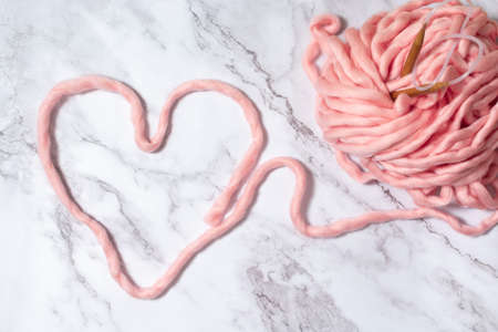 heart made of giant merino yarn for arm knitting on a marble background