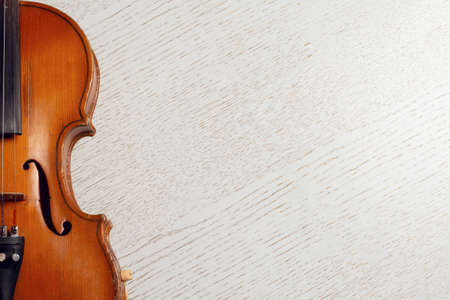 Wooden string instrument violin on white wooden background with copy spaceの写真素材