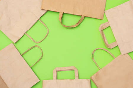 Craft paper recyclable bags on green background with copy space for your text. Zero waste shopping and plastic free conceptの写真素材