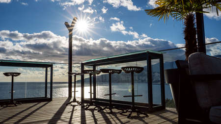 bar chairs on a pier on the summer open terrace with panoramic view over the sea.