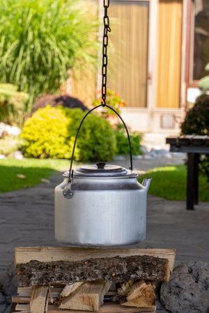 Iron tea kettle ready to be warmed up on a fire outdoor. Alternative way to supple cooking without gas and electricityの写真素材