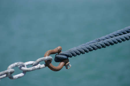 A rope tied to a chain to secure the yact while berthingの写真素材