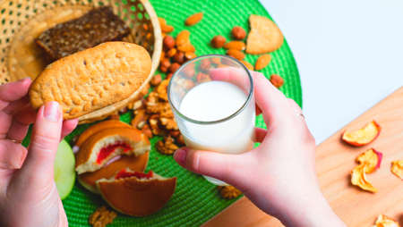 The girl dips the biscuits into the milk. Breakfastの写真素材