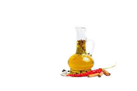 Olive oil with herbs and dried red chile pepper against white backgroundの写真素材