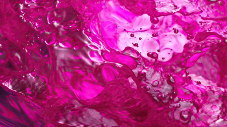 The image features an abstract and fluid background that resembles liquid. The transparency of the liquid adds to its intriguing nature. The macro perspective allows for a detailed view of the surface, highlighting the intricate shapes and patterns formed by the fluid. The backdrop is minimal, making it suitable for various presentation purposes.の素材