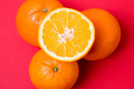 Arrangement of oranges against a red backgroundの写真素材