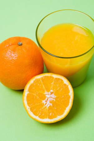 Freshly squeezed orange juice with half and whole orangeの写真素材