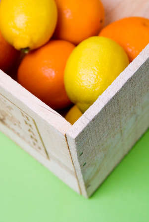 Fresh oranges and lemons in a wooden boxの写真素材