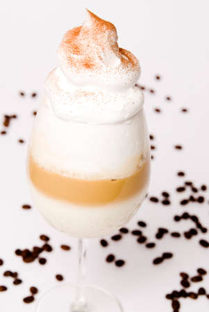 Latte macchiato with layers in the wine glass and coffee beans