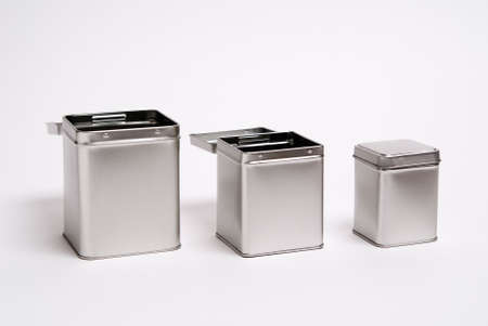 Three metal cans in different sizes with hinged lids