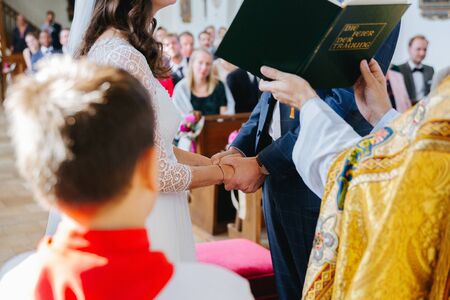 Bride and groom holding hands during the wedding ceremonyの写真素材