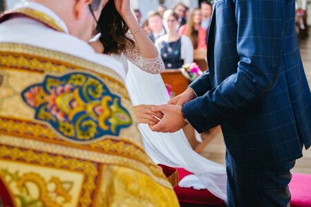 Bride and groom holding hands during the wedding ceremonyの写真素材