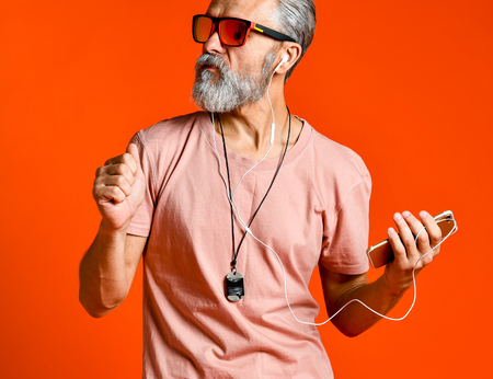 Enjoying the sound of music. Studio portrait of handsome senior man with gray beard and headphones.