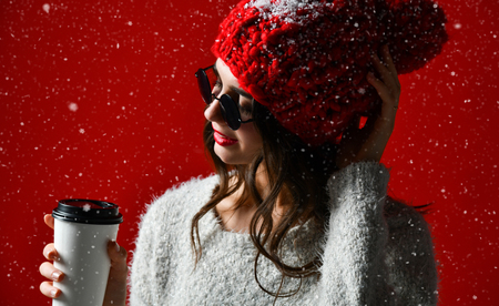 winter, people, happiness, drink and fast food concept - woman in hat with takeaway tea or coffee cup, side viewの写真素材