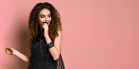 Singer. young pretty brunette woman singing in microphone isolated close upの写真素材