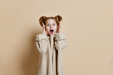 Wow. Beautiful female half-length front portrait isolated on nude studio background. Young emotional surprised teen girl standing with open mouth. Human emotions, facial expression concept.の写真素材