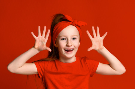 Adorable preschooler girl showing palms and funny grimace. Cute joyful Hispanic child having fun. Isolated on white. Fun conceptの写真素材