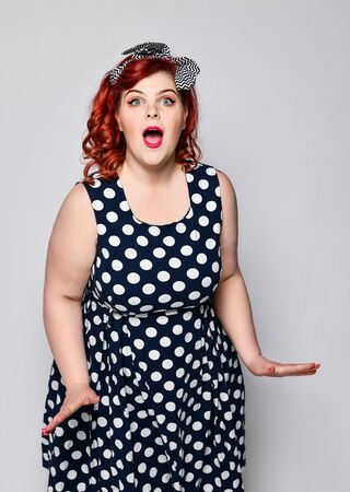 Beautiful style portrait of a full fat woman plus size in retro dress and makeup, polka dot dress, surprised and admired by something. Pin up girl vintage.の写真素材