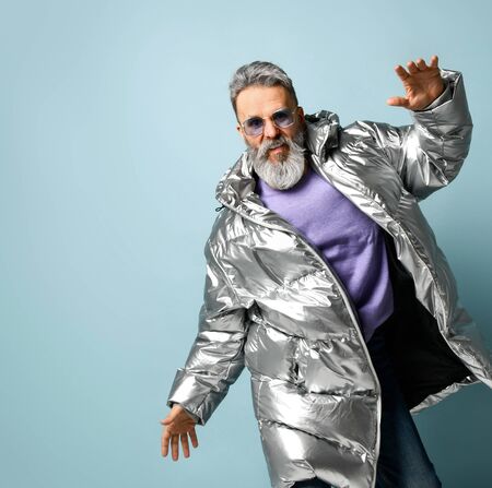 White-haired, bearded macho man in stylish purple glasses, oversized silver down jacket, jeans...