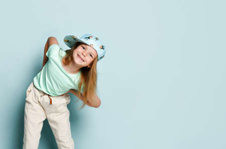 Cute blonde in a T-shirt, white pants and a cap with a picture of pineapples. She leaned forward,...