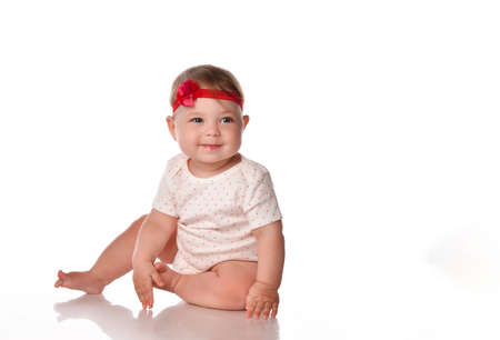 Adorable little baby girl laughing, creeping playing in the studio, isolated on white background.の写真素材