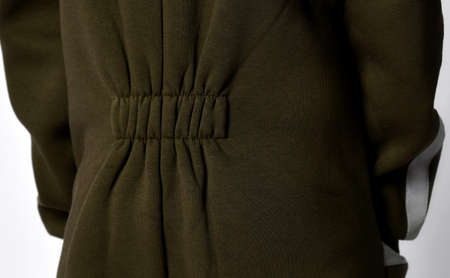 Waist tightening part of dark green warm jumpsuit for autumn and winter crop closeup detailed shot....