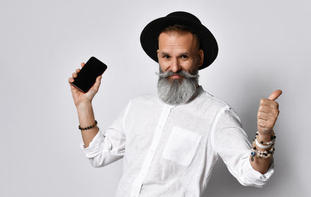 Bearded hipster man posing with blank smartphone