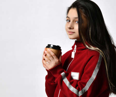Caucasian preteen girl model in tracksuit drinking coffee cappuccino headshot portraitの写真素材