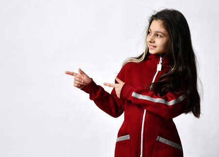 Caucasian preteen girl model in fashion tracksuit pointing to copy space with palmの写真素材