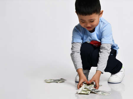 Cool little asian boy throwing money cash studio shotの写真素材