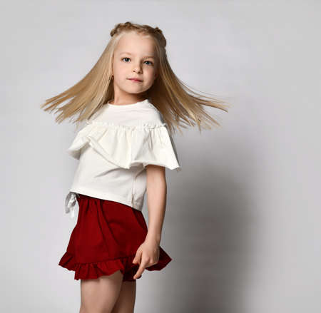 Portrait of a stylish little girl in summer clothes on a white background.の写真素材