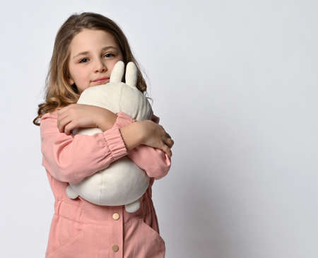 Girl hugs a plush toy on a light backgroundの写真素材