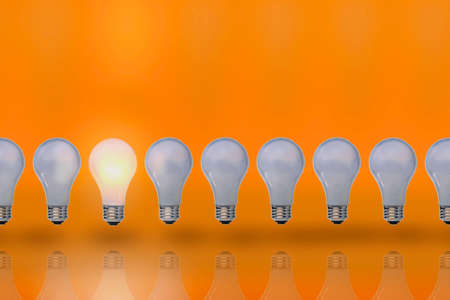 Light bulbs stand in row, one included の写真素材