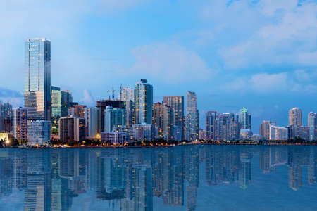 A shot of beautiful Downtown Miami skyline after sunset with reflection in the water  All logos and...