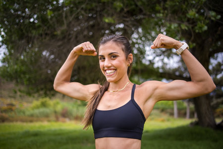 Young female athlete in black sportswear exercising outdoors in a scenic rural setting. Captured in...