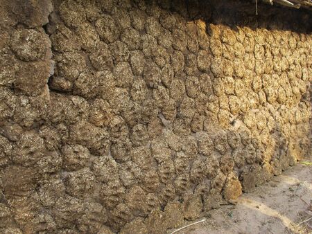 House wall made from cow dung in country side of India with sunlight hits the right bankの写真素材