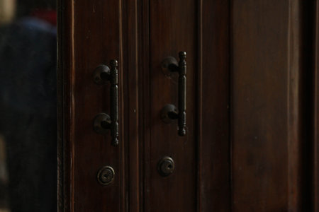 A closeup of an old, rustic wooden door handle, showcasing vintage craftsmanship and design.