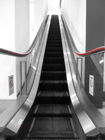 escalator with red hand rails and glass sidesの写真素材