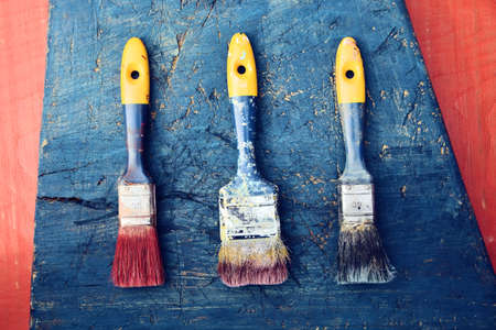 old paint brushes on wooden backgroundの写真素材