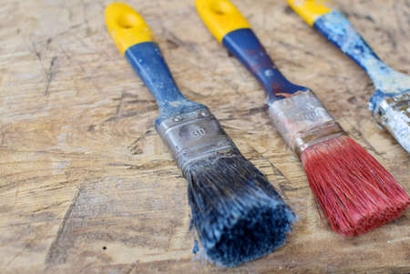 old paint brushes on wooden backgroundの写真素材