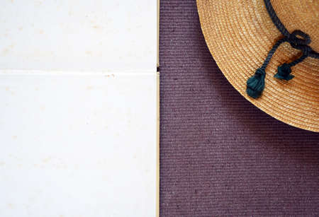 aged paper and vintage hat on textile background top viewの写真素材