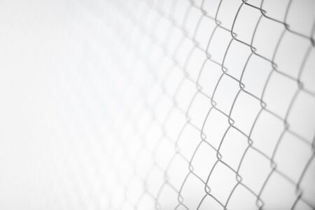 Close up rusty wire fence and blurred nature background. Wire netting or metal fence net and out of focus backgroundの写真素材