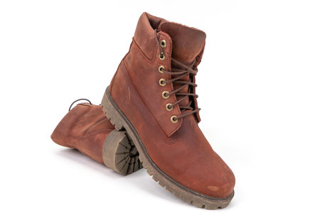 Pair of worn brown leather boots isolated on white backgroundの写真素材
