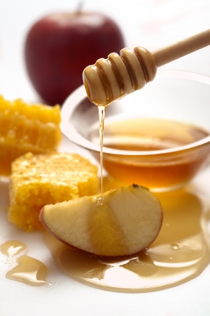 Honey dripping on a appleの写真素材