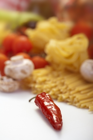 Pepper, spaghetti and vegetables in backgroundの写真素材